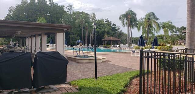 view of swimming pool featuring area for grilling, a patio, and a jacuzzi