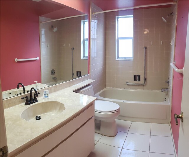 full bathroom featuring tile patterned floors, tiled shower / bath, vanity, and toilet