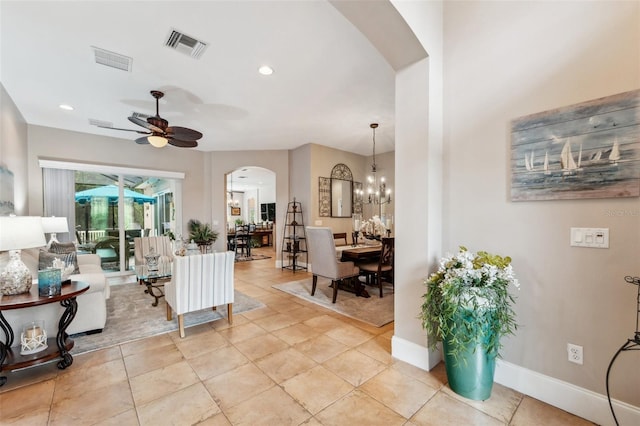 living room with ceiling fan with notable chandelier and light tile patterned floors