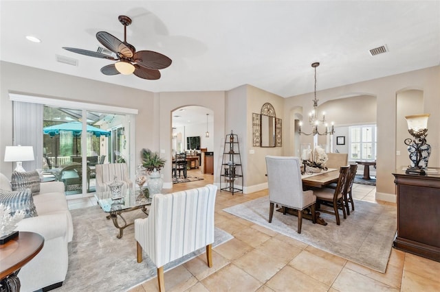 tiled dining area featuring ceiling fan with notable chandelier