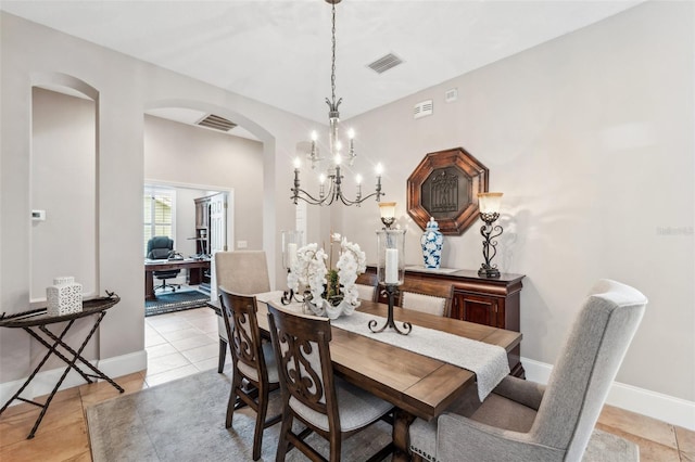 dining space featuring light tile patterned floors and a chandelier