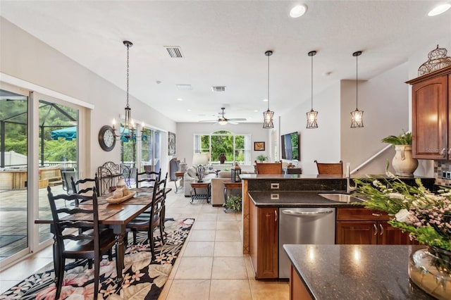 kitchen with light tile patterned flooring, ceiling fan with notable chandelier, decorative light fixtures, dishwasher, and sink