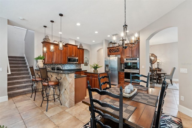 kitchen with pendant lighting, backsplash, stainless steel appliances, and kitchen peninsula