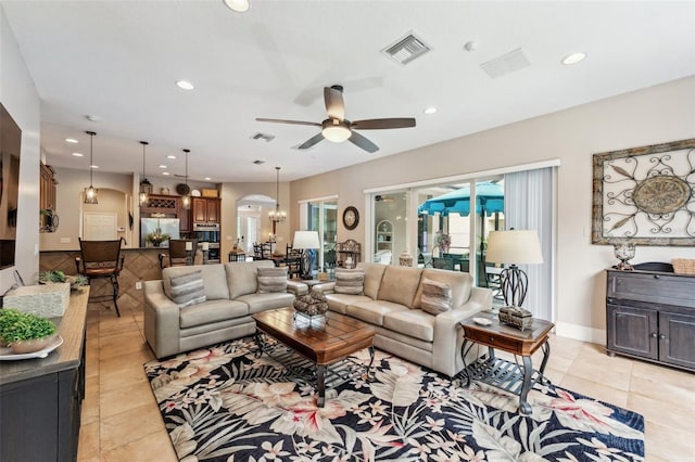 living room with ceiling fan with notable chandelier and light tile patterned floors