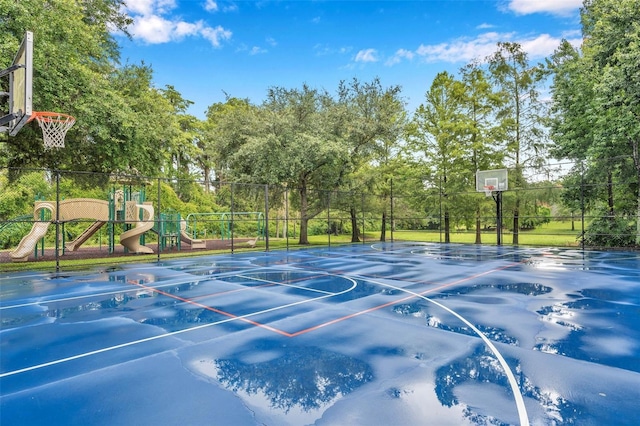 view of basketball court featuring a playground