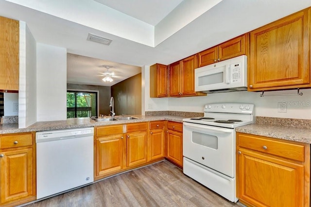 kitchen with sink, white appliances, ceiling fan, and light wood-type flooring