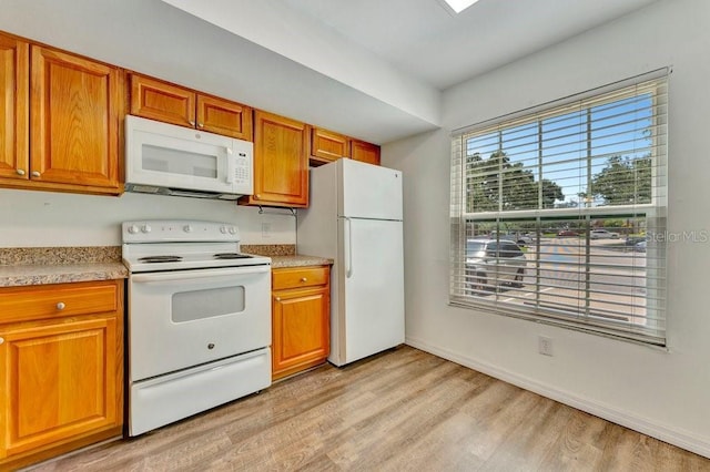 kitchen with white appliances and light hardwood / wood-style floors