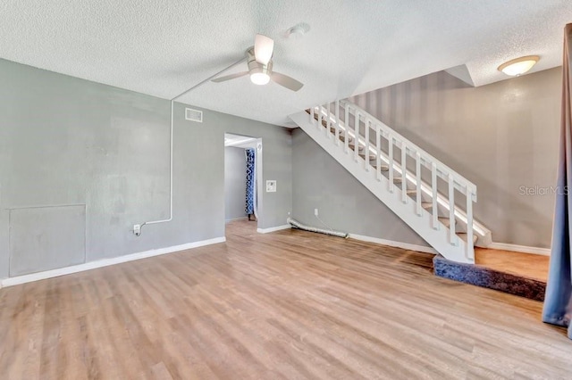 unfurnished living room with ceiling fan, wood-type flooring, and a textured ceiling