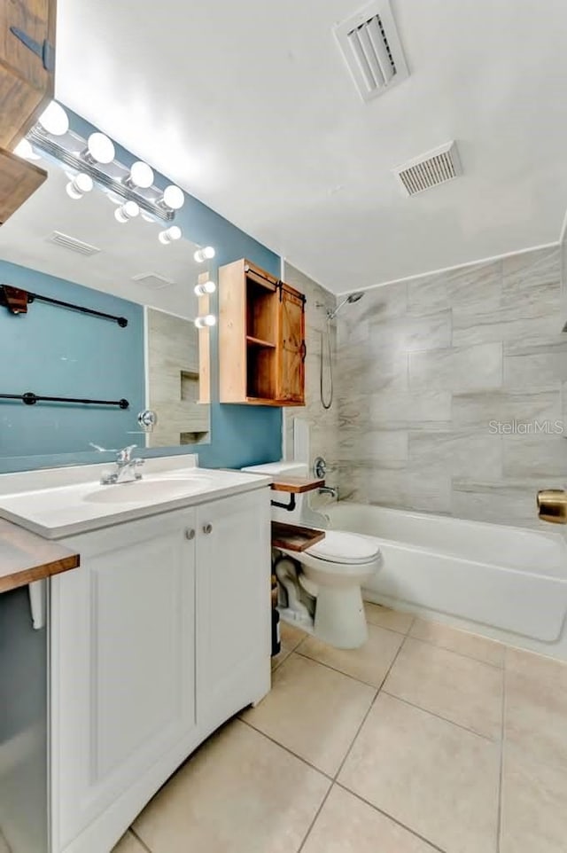 full bathroom featuring tile patterned floors, toilet, tiled shower / bath combo, and vanity