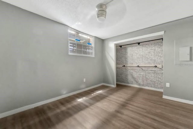 unfurnished bedroom with wood-type flooring, a textured ceiling, and a closet