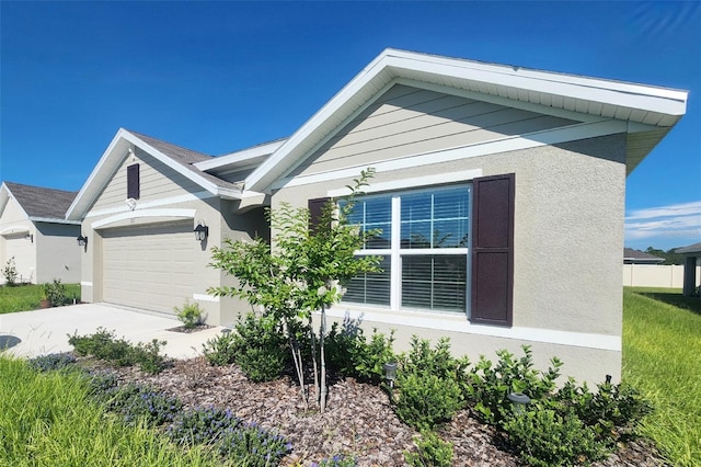 view of front facade featuring a garage, driveway, and stucco siding