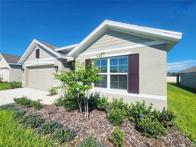 view of front of property featuring a garage, driveway, and stucco siding