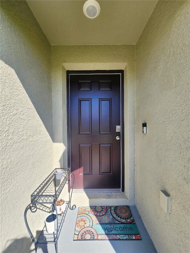 doorway to property with stucco siding