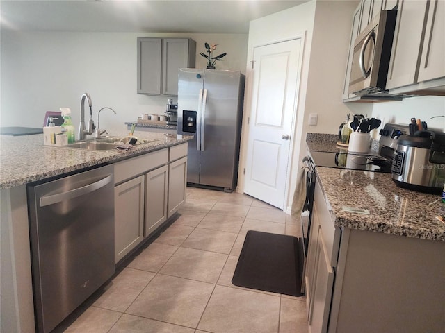 kitchen featuring gray cabinets, sink, light tile patterned floors, and stainless steel appliances