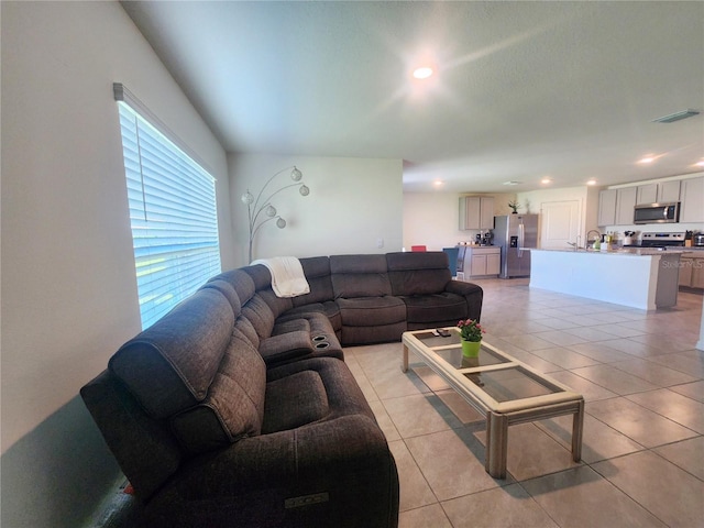 living area with light tile patterned floors, visible vents, and recessed lighting