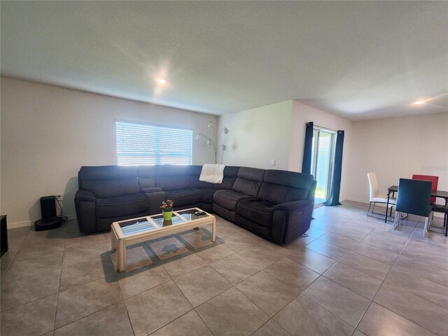 tiled living room featuring a textured ceiling