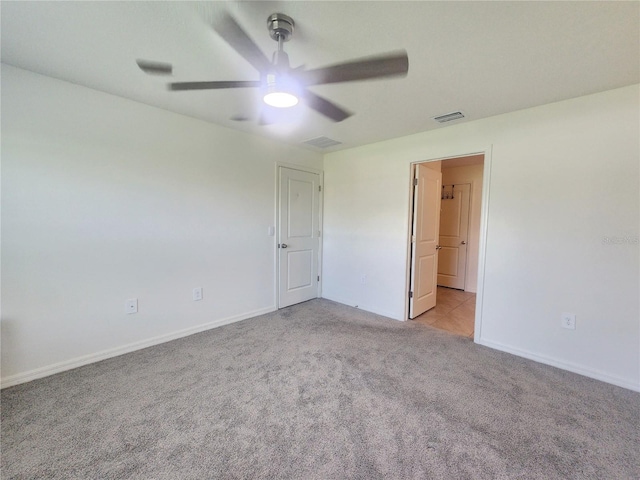 unfurnished room featuring baseboards, a ceiling fan, visible vents, and light colored carpet