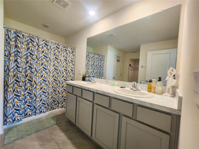 bathroom featuring tile patterned flooring and dual bowl vanity