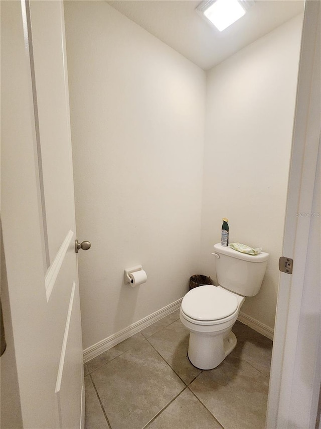 bathroom featuring baseboards, toilet, and tile patterned floors