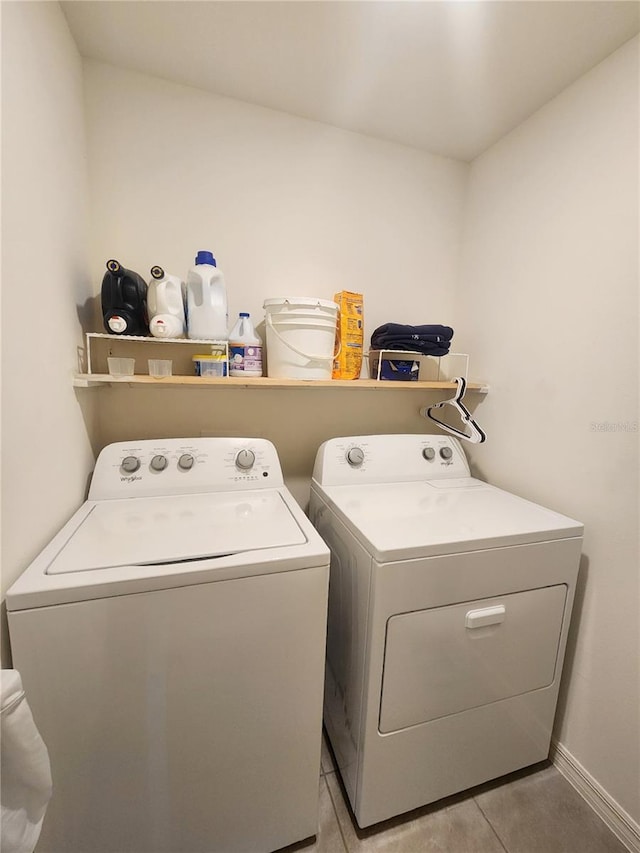 laundry room with light tile patterned flooring and washing machine and clothes dryer