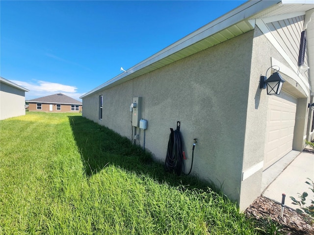 view of home's exterior with a yard, an attached garage, and stucco siding