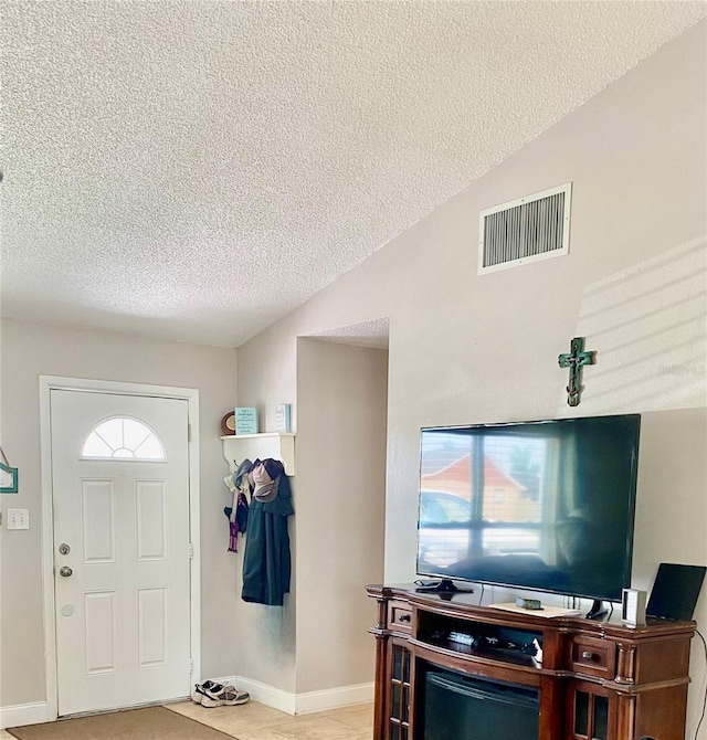 entrance foyer featuring plenty of natural light, visible vents, vaulted ceiling, and a textured ceiling