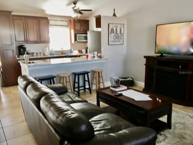 living room with ceiling fan and light tile patterned flooring