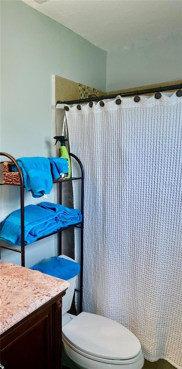 full bathroom with a shower with shower curtain, vanity, and toilet