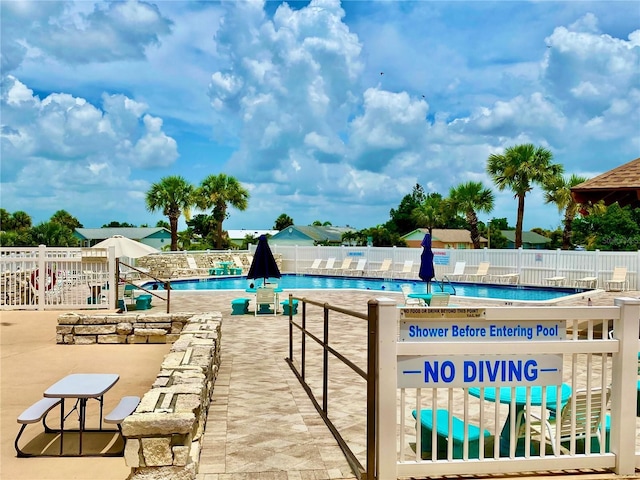 community pool featuring a patio and fence