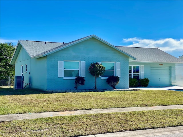 ranch-style house with cooling unit, a garage, and a front yard