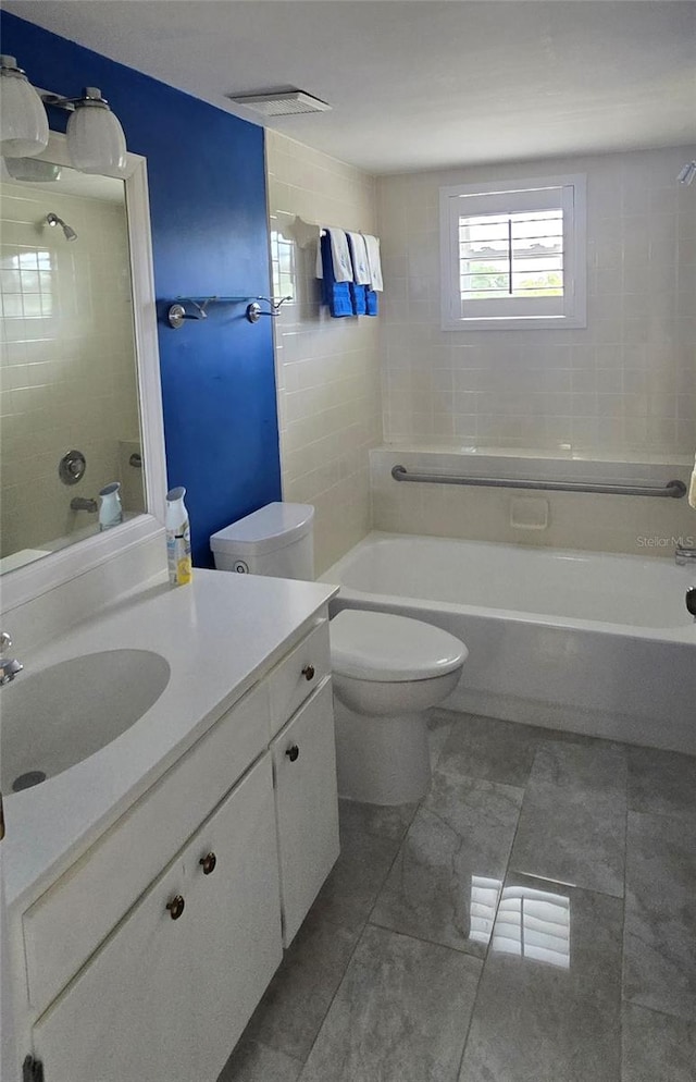 full bathroom with vanity, tiled shower / bath, tile patterned flooring, and toilet