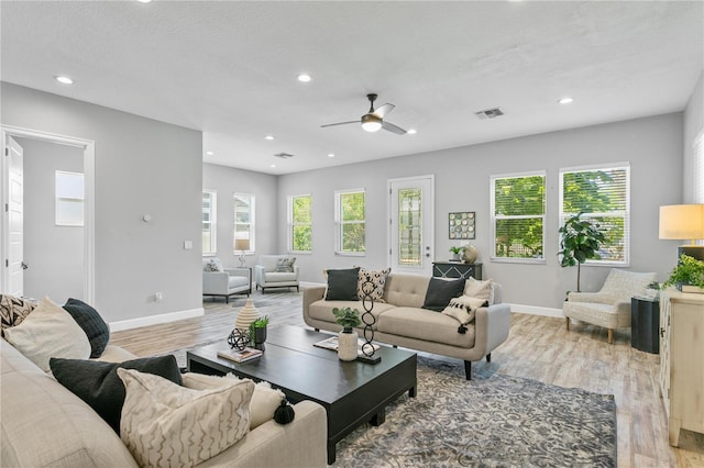 living area featuring light wood-type flooring, plenty of natural light, visible vents, and recessed lighting