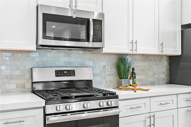 kitchen featuring stainless steel appliances, white cabinets, and tasteful backsplash