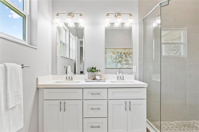 full bath with double vanity, a shower stall, and a sink