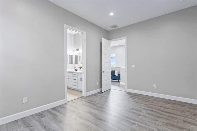 unfurnished bedroom with light wood finished floors, recessed lighting, visible vents, ensuite bathroom, and baseboards