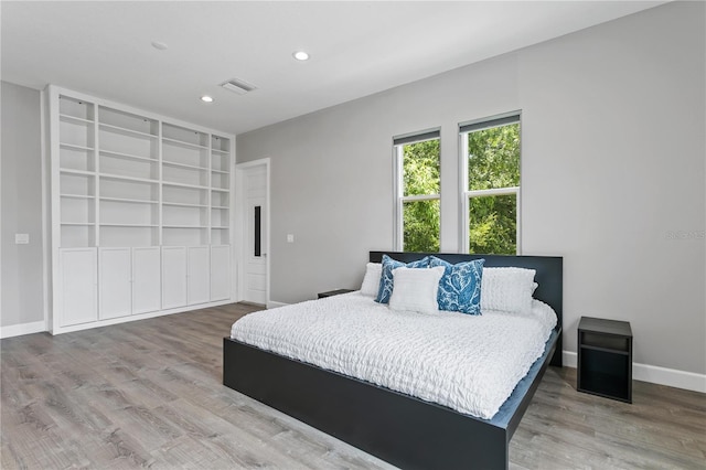 bedroom featuring recessed lighting, visible vents, baseboards, and wood finished floors