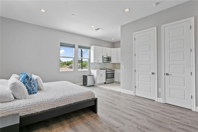 bedroom with light wood-type flooring, visible vents, baseboards, and recessed lighting