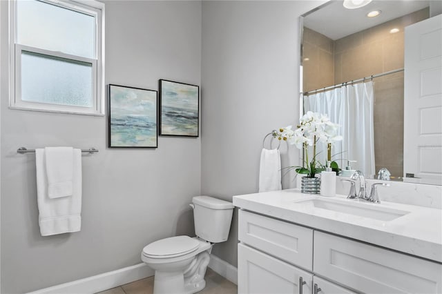 bathroom featuring tiled shower, vanity, toilet, and baseboards