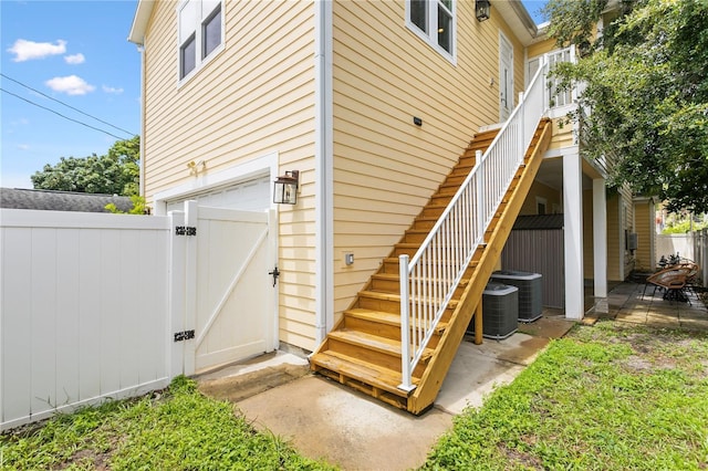 exterior space with a gate, a patio area, fence, and stairway