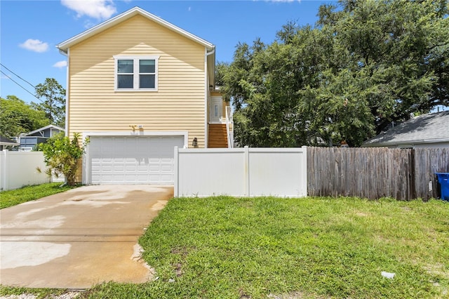 view of home's exterior with driveway, an attached garage, fence, and a lawn