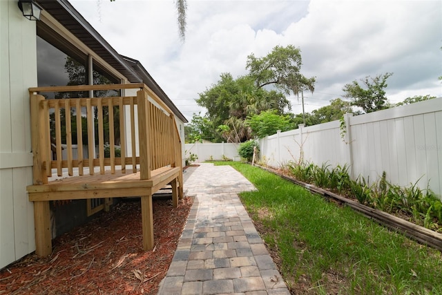 view of yard with a wooden deck and a patio