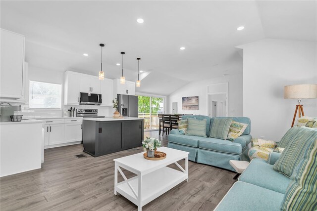 living room with lofted ceiling and light hardwood / wood-style flooring