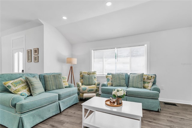 living room featuring lofted ceiling and hardwood / wood-style floors