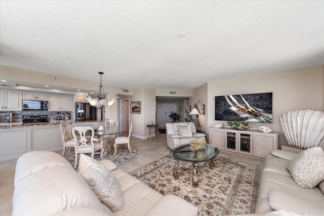 tiled living room with a notable chandelier and a textured ceiling