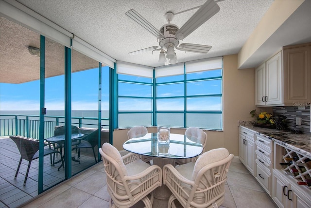 interior space featuring a water view, a textured ceiling, and ceiling fan