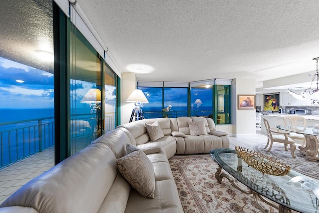 tiled living room featuring a wall of windows, a water view, and a textured ceiling