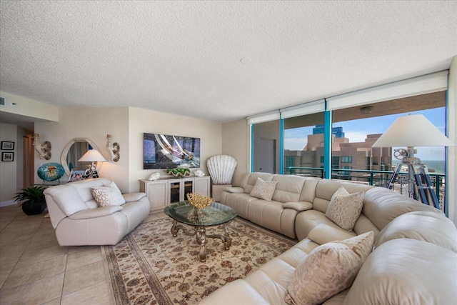 tiled living room with a textured ceiling and floor to ceiling windows