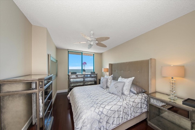 bedroom with ceiling fan, dark hardwood / wood-style floors, a closet, and a textured ceiling