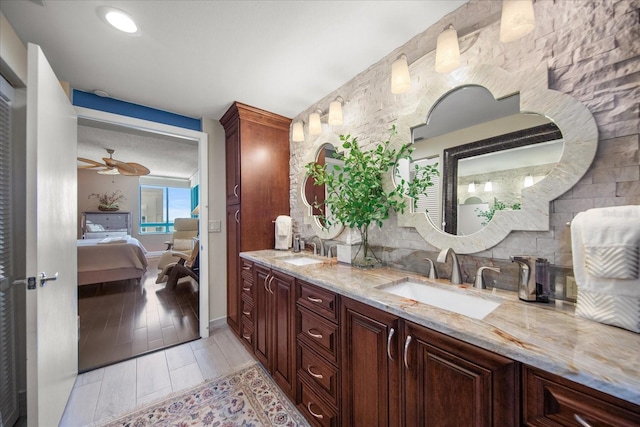 bathroom featuring double vanity, ceiling fan, and wood-type flooring