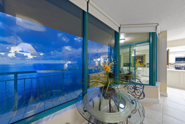 sunroom featuring a water view